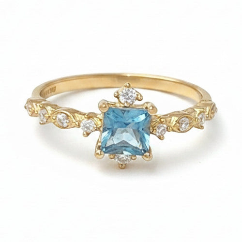 Jade18k yellow gold ring with a square-cut blue gemstone center and sparkling accent stones on a detailed band.