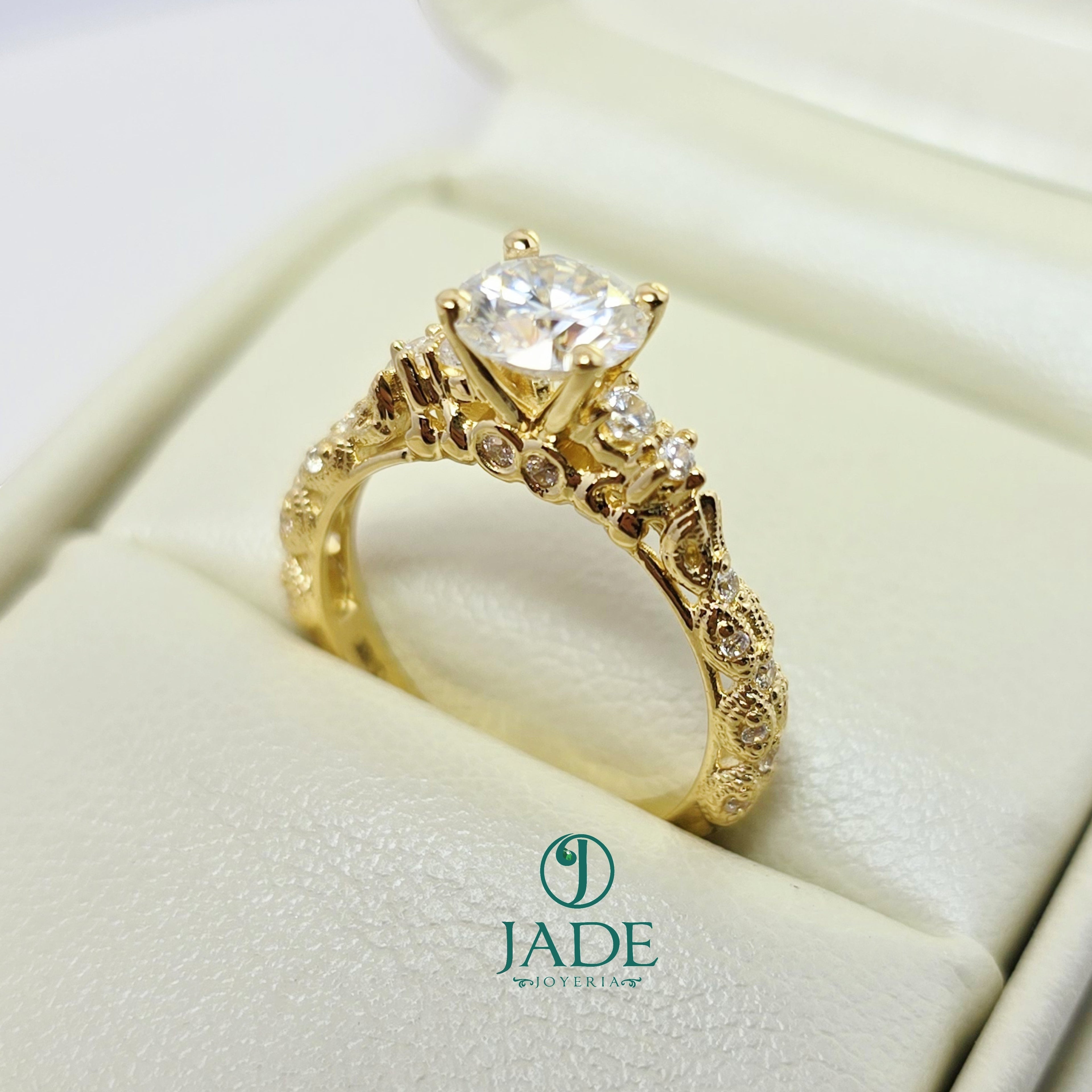 Jade18k Camila engagement ring in 18k orange gold with a central cubic zirconia and intricate detailing on the band.