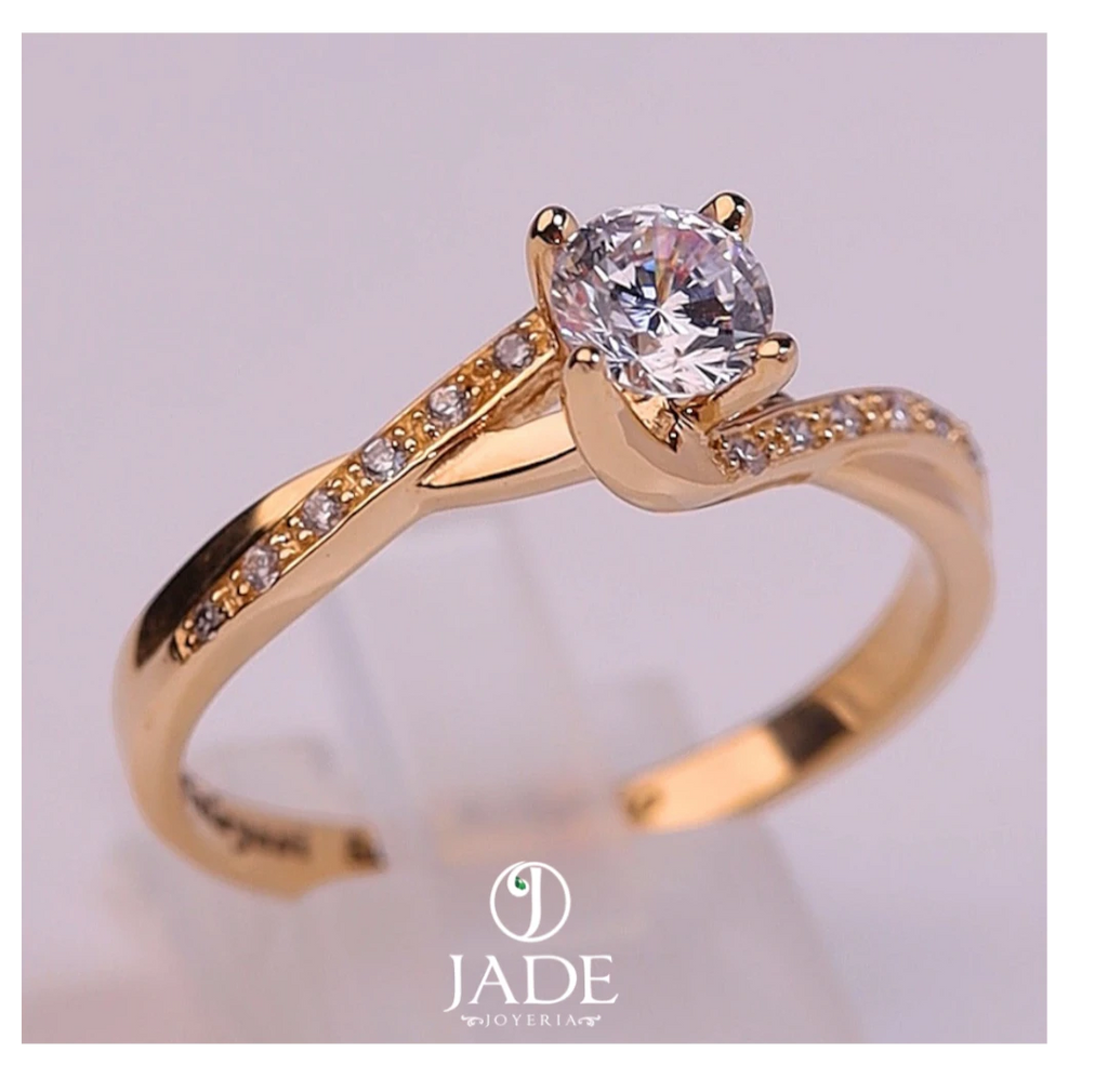 Jade18k Paulina engagement ring in 18k orange gold with a central cubic zirconia and small stones along the band.