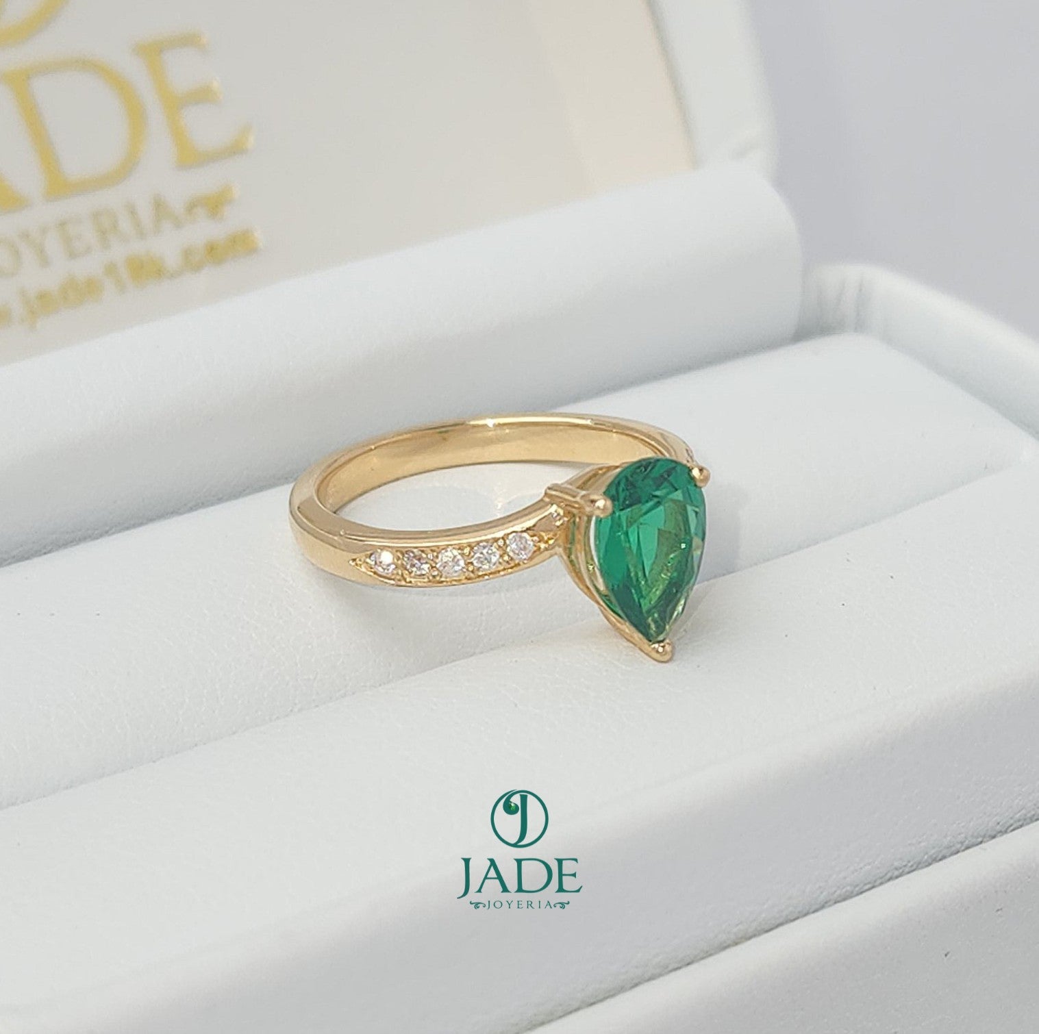 Jade18k yellow gold ring with a pear-cut green zircon center and small moissanite stones on the band.