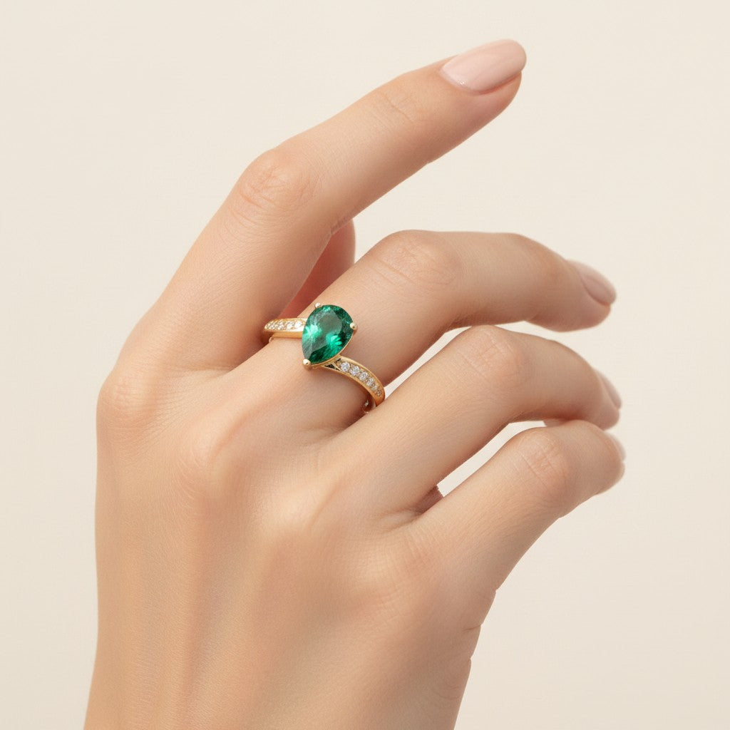 Jade18k yellow gold ring with a pear-cut green zircon center stone and small moissanite side stones.