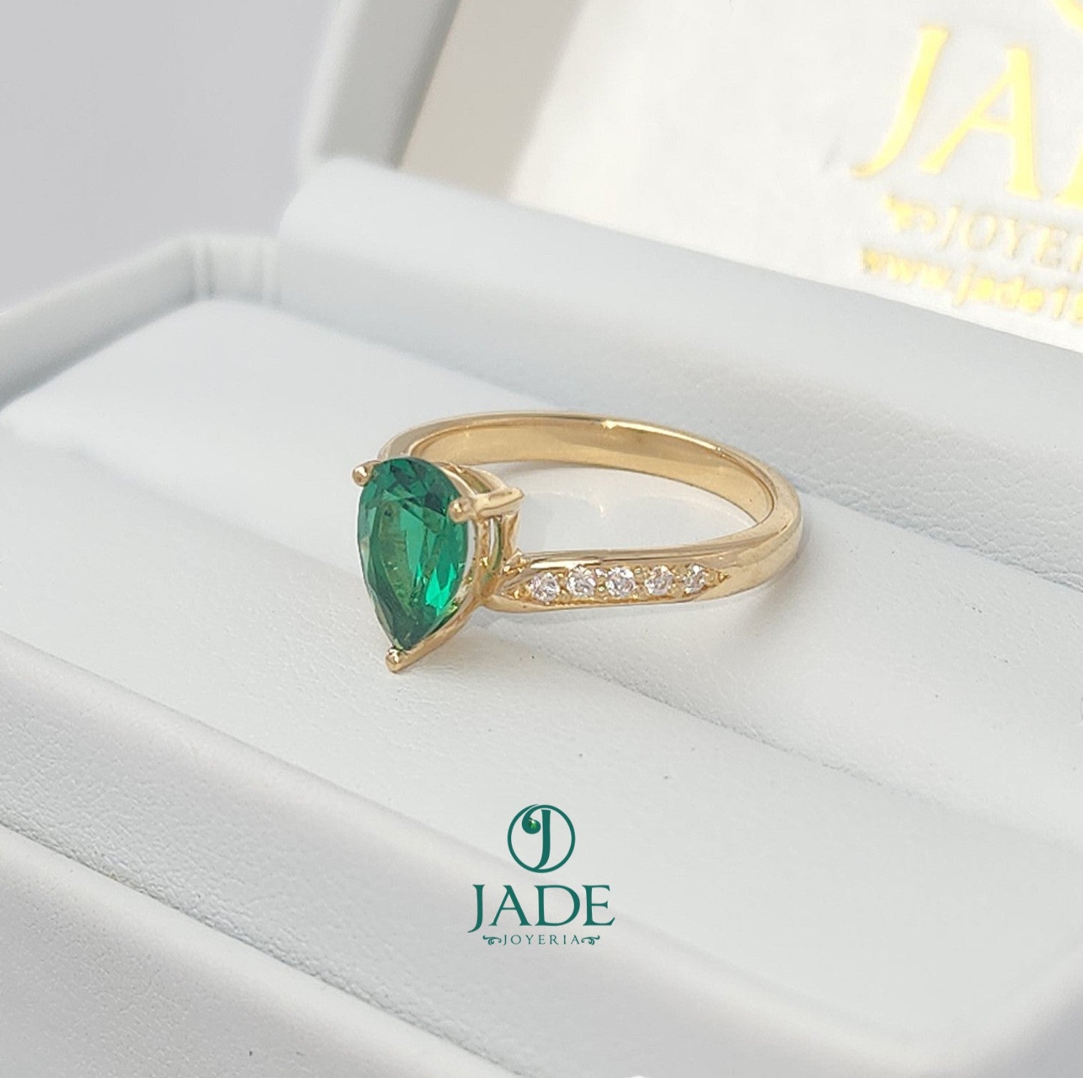 Jade18k yellow gold ring with a pear-cut green zircon center stone and small moissanite side stones.
