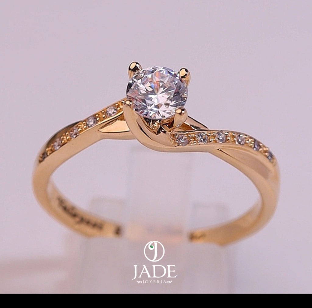 Jade18k Paulina engagement ring in 18k orange gold with a central cubic zirconia and small stones on the band.