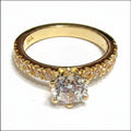 Jade18k Julieta engagement ring in 18k orange gold with a central cubic zirconia and pavé stones on the band.