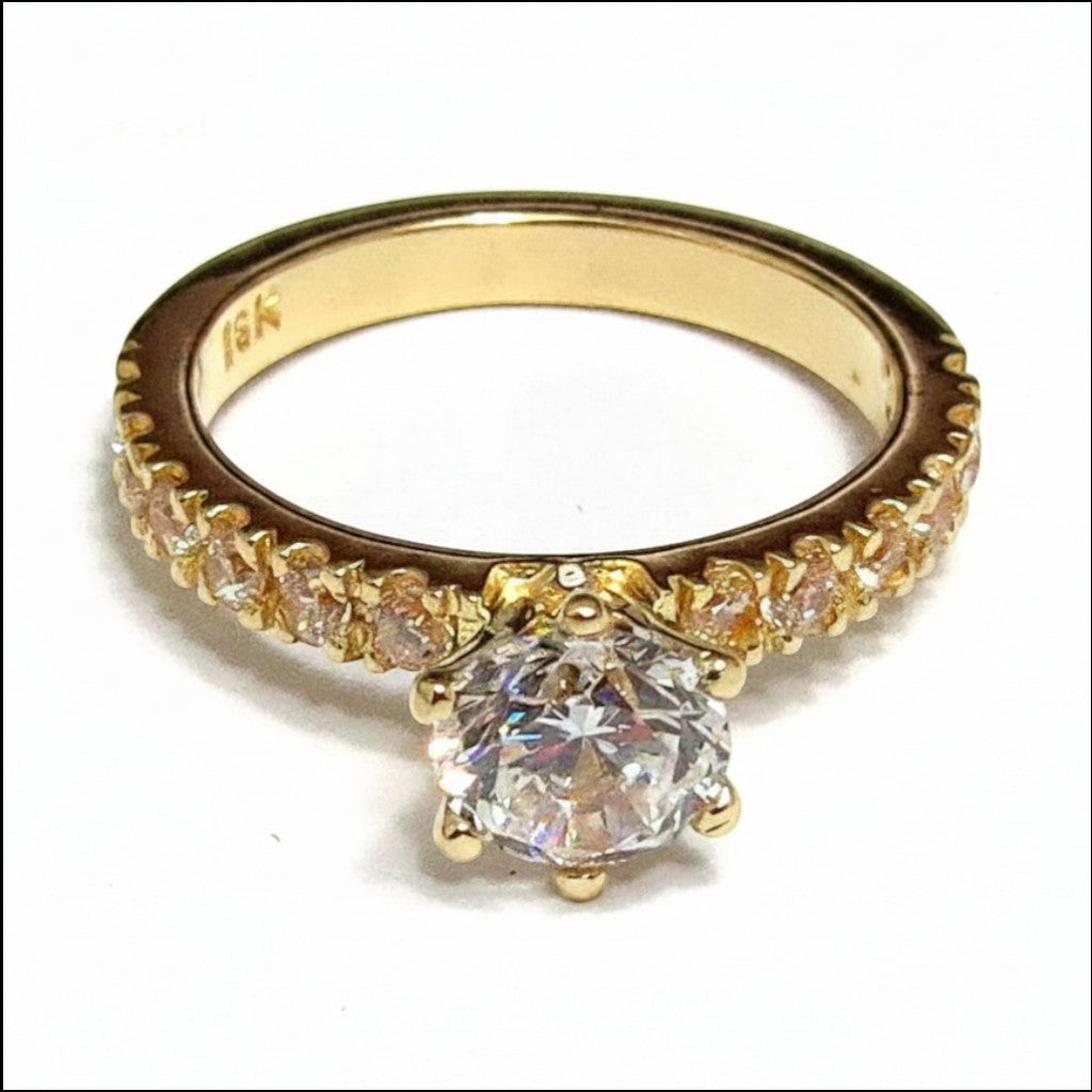 Jade18k Julieta engagement ring in 18k orange gold with a central cubic zirconia and pavé stones on the band.