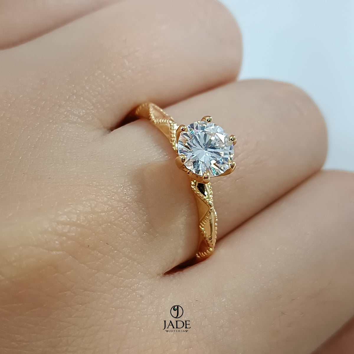 Jade18k Lucie engagement ring in 18k orange gold with a round cubic zirconia stone and intricate band detail.