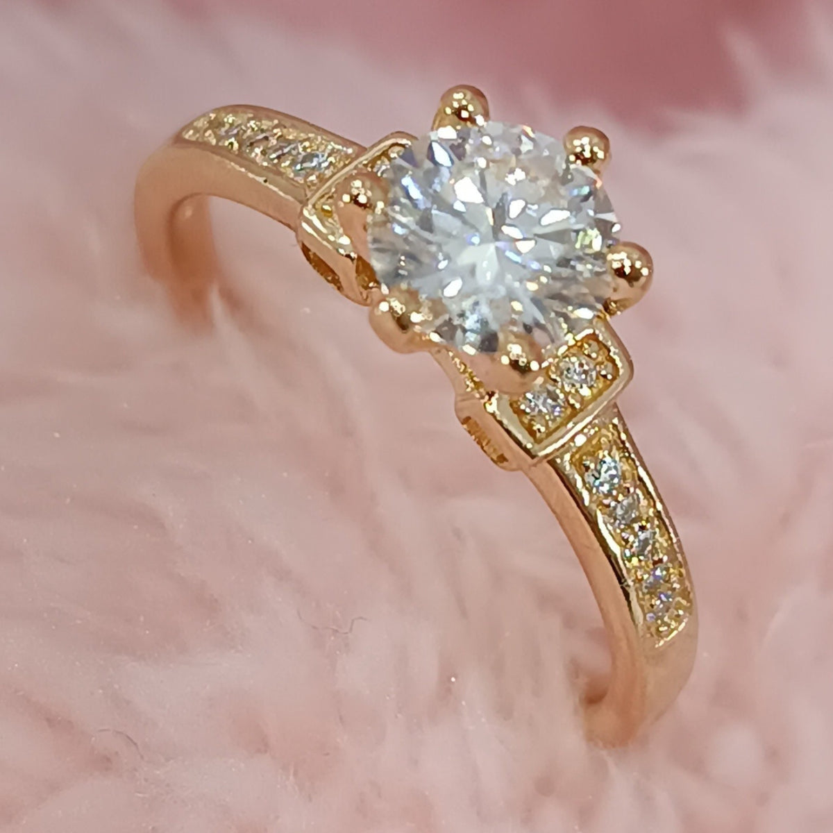 Jade18k Lú engagement ring in 18k orange gold with a central cubic zirconia and pavé stones on the band.