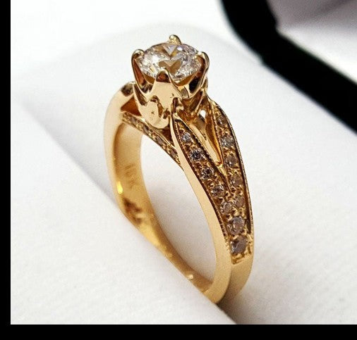 Jade18k 18k orange gold engagement ring with a floral setting and pave-set cubic zirconia stones on the band.