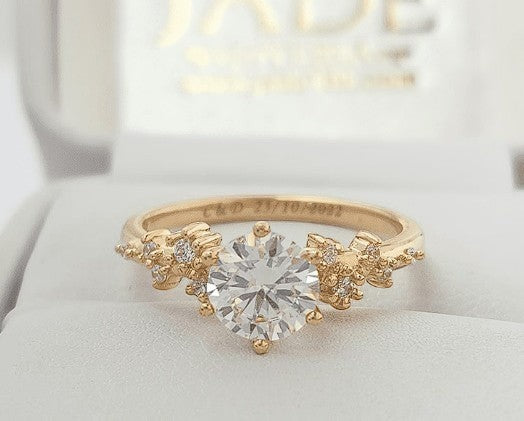 Jade18k 18k orange gold engagement ring with a central zircon stone and small diamonds on the band.