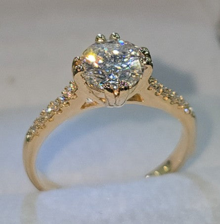 Jade18k 18k orange gold engagement ring with a large moissanite center stone and smaller moissanite accent stones on the band.