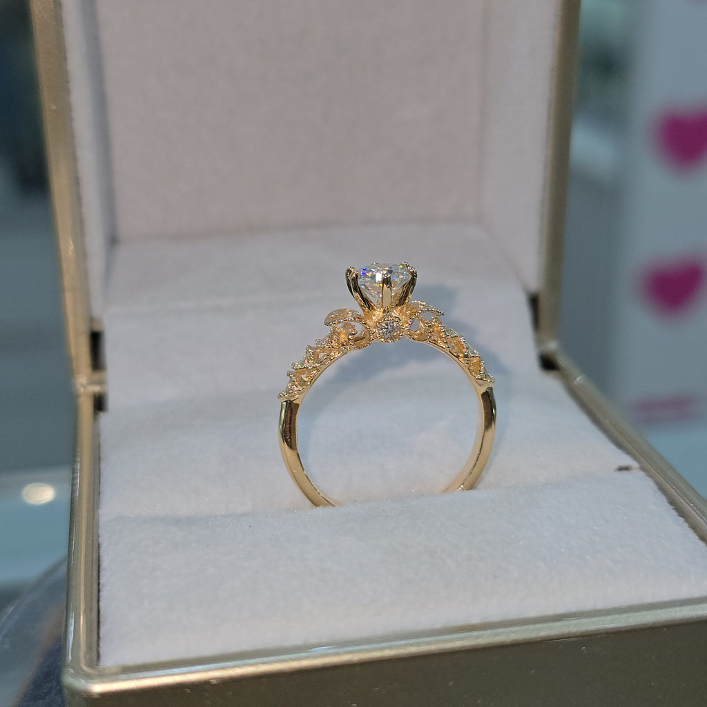 Jade18k 18K orange gold engagement ring with a central moissanite stone and intricate detailing on the band.