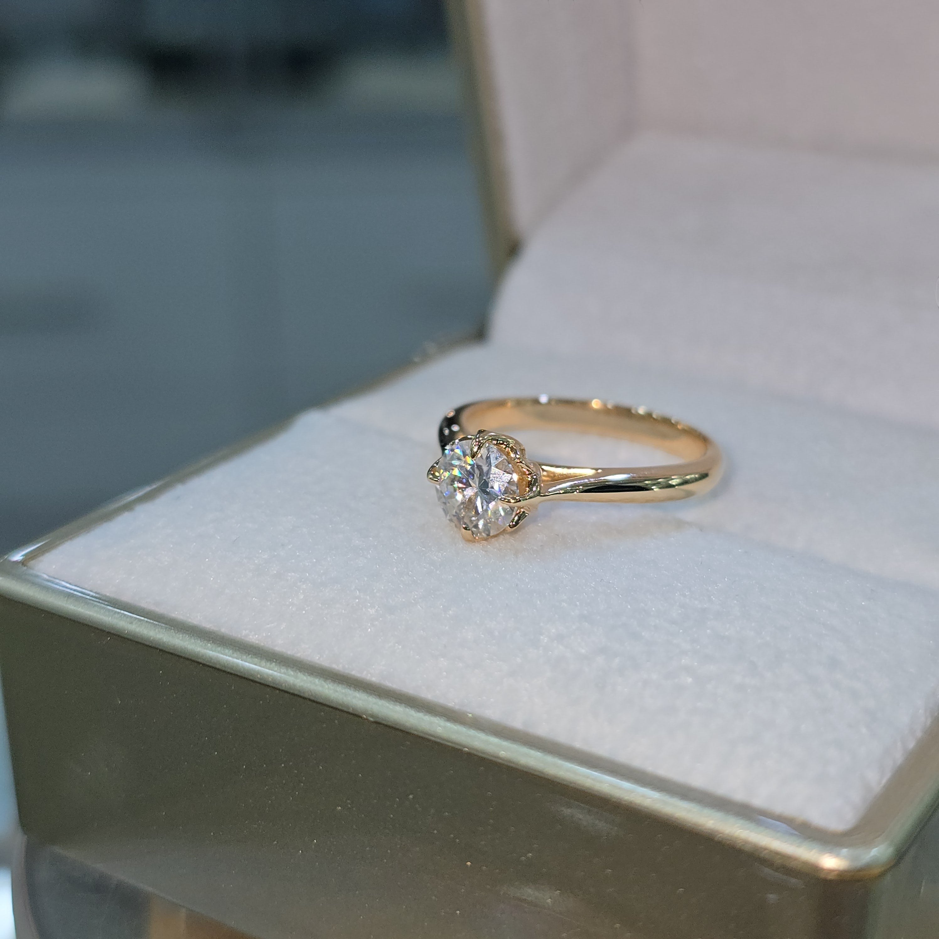 Jade18k orange gold 18k engagement ring with moissanite center stone and floral setting.