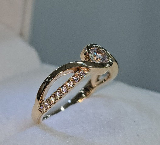 Jade18k orange gold ring with pave cubic zirconia stones and a pear-cut center stone.