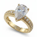 Jade18k yellow gold engagement ring featuring a large pear-cut diamond center stone and pavé diamond band with intricate detailing.