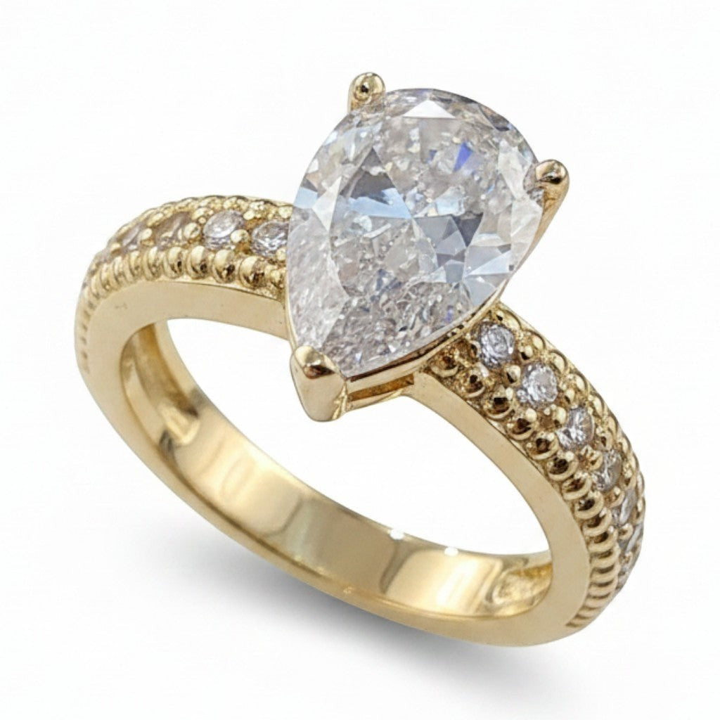 Jade18k yellow gold engagement ring featuring a large pear-cut diamond center stone and pavé diamond band with intricate detailing.