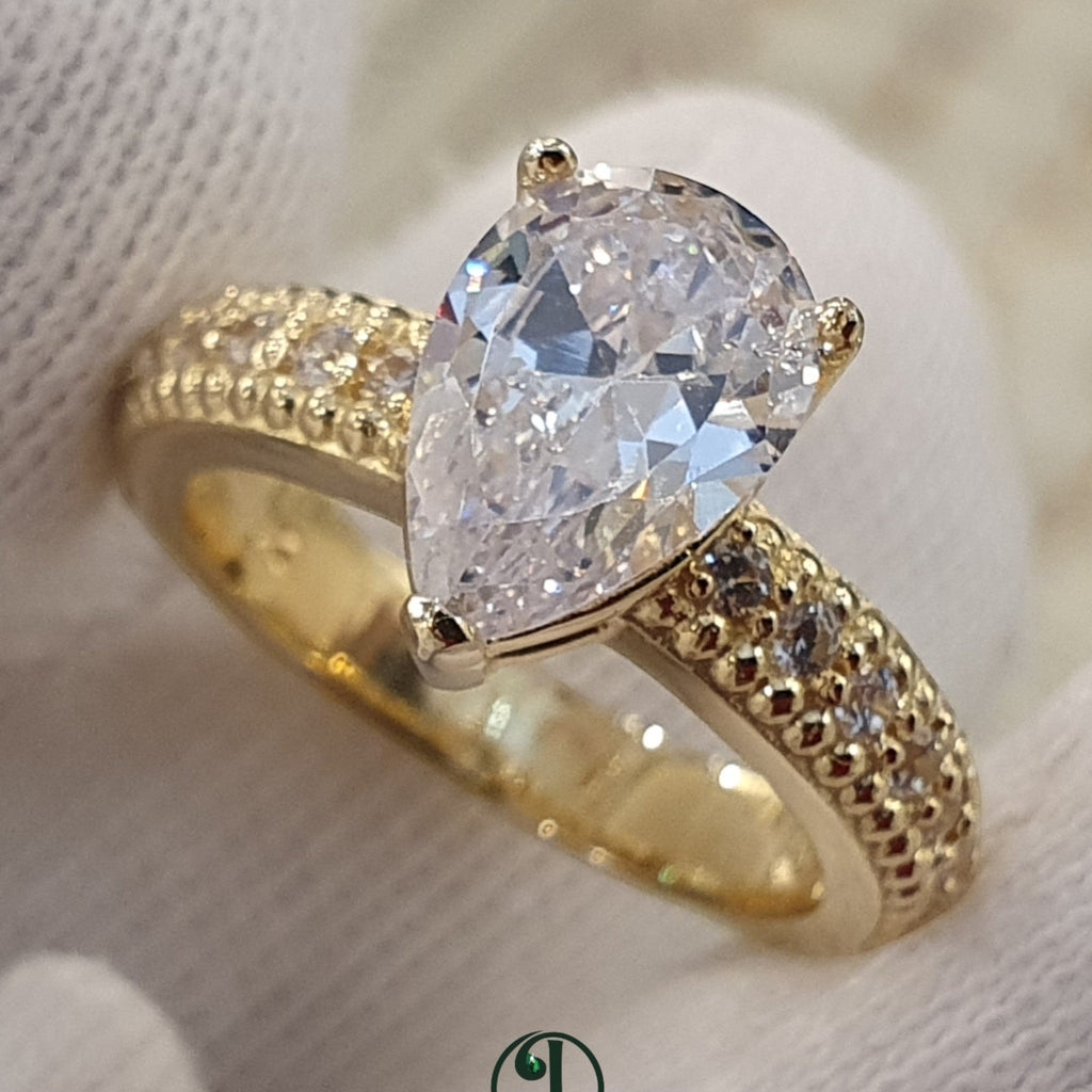 Jade18k yellow gold pear cut diamond engagement ring with pavé band and vintage detailing.