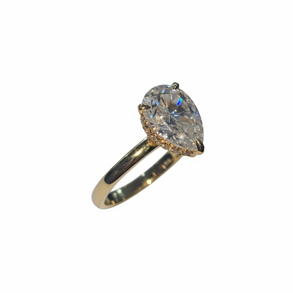 Jade18k 18k yellow gold pear cut moissanite engagement ring with a halo of small diamonds.