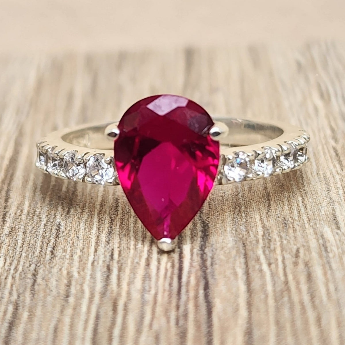 Jade18k silver ring with a pear-cut deep red gemstone and pave band. Elegant statement ring.
