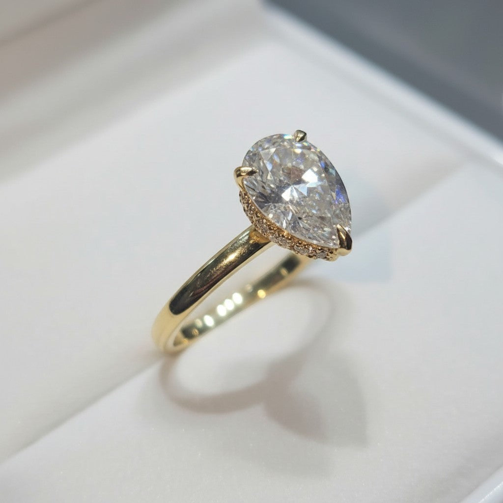 Jade18k 18k yellow gold pear-cut moissanite engagement ring with halo accent stones.