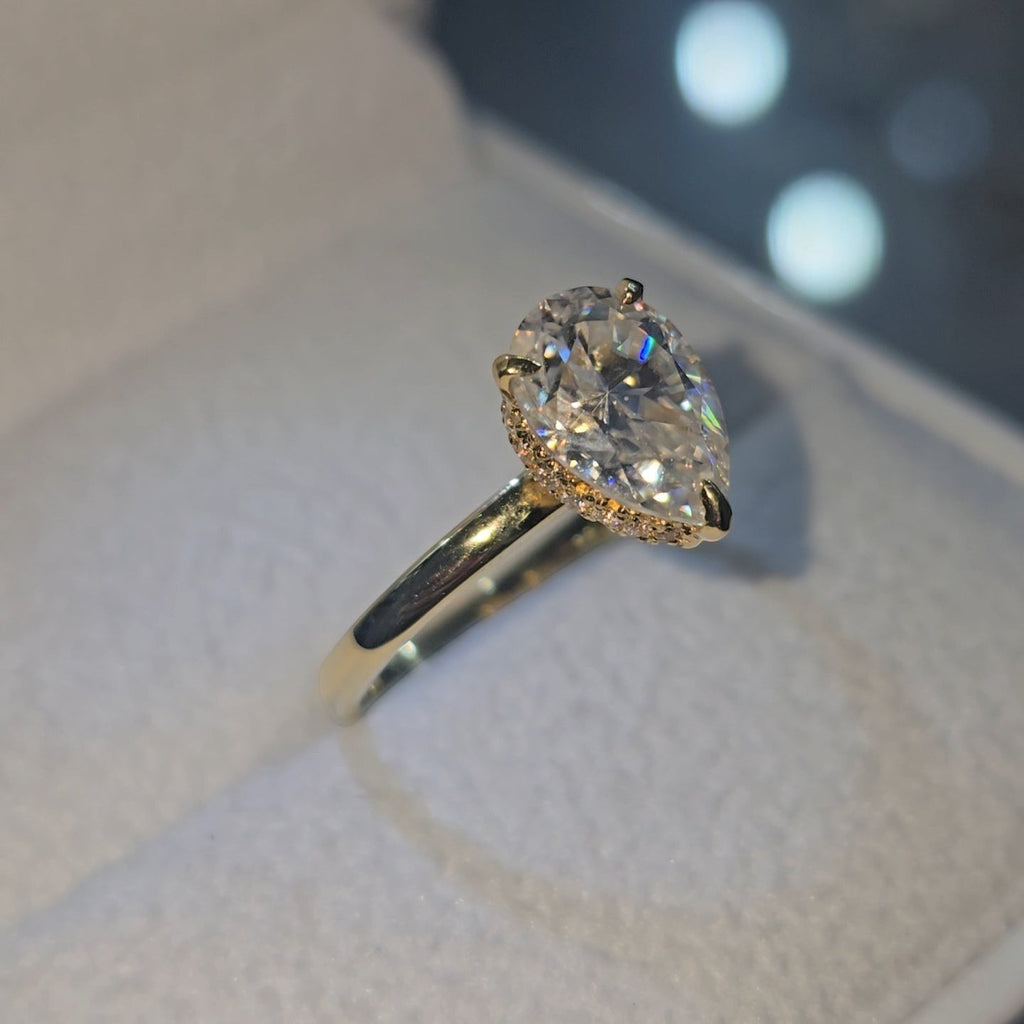 Jade18k 18k yellow gold pear-cut moissanite engagement ring with pavé halo setting.