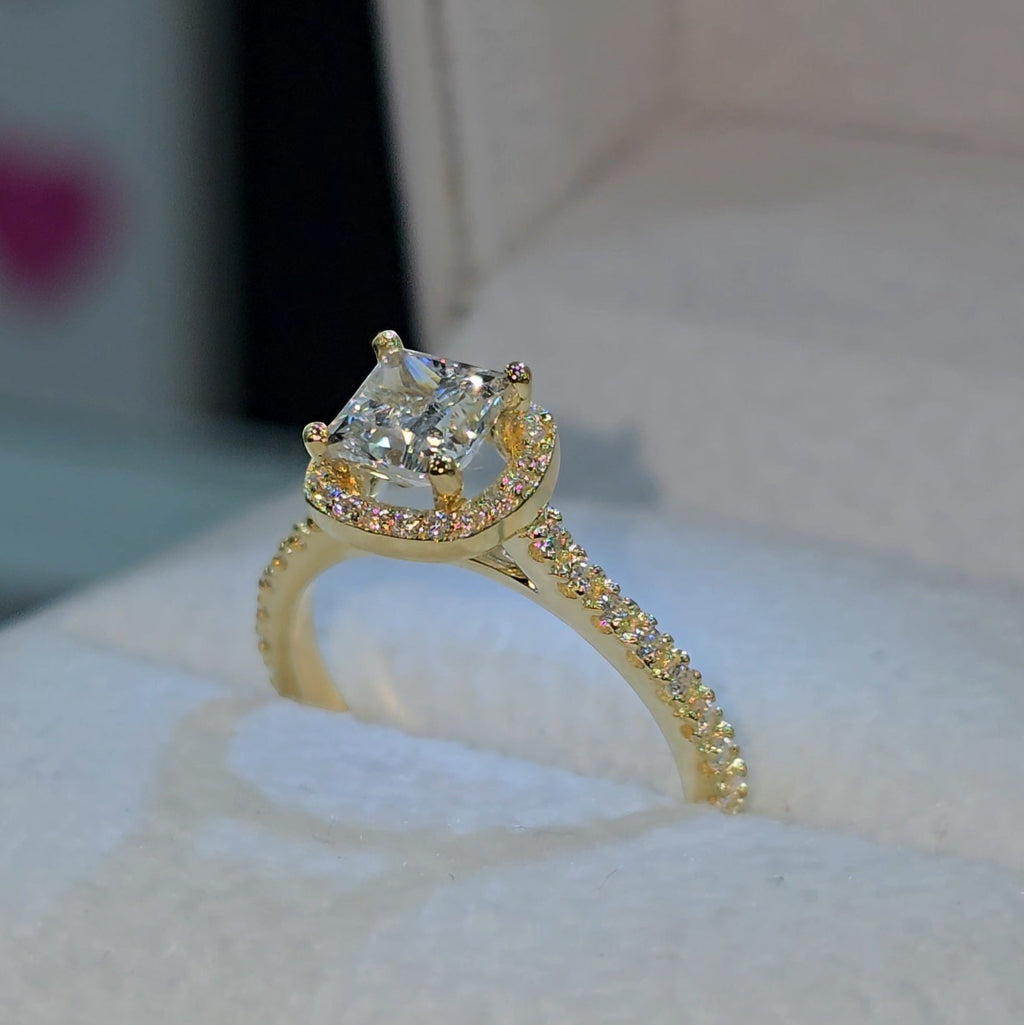Jade18k princess cut diamond engagement ring with halo and pavé band in 18k yellow gold.