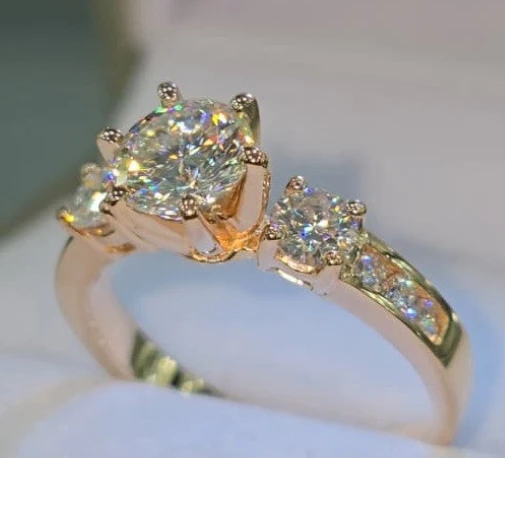 Jade18k 18k rose gold ring with a large central moissanite and smaller accent stones, sunflower design.