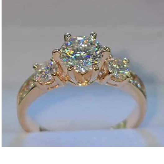 Jade18k 18k rose gold ring with a large central moissanite and two smaller side stones, sunflower design.