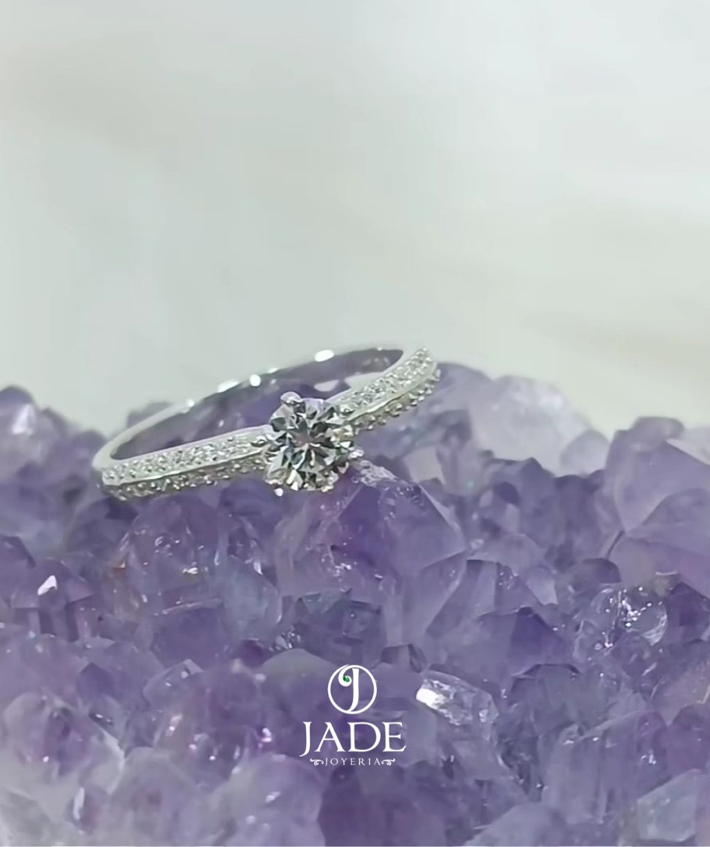 Jade18k engagement ring in silver with a central diamond and pave-set stones on the band.