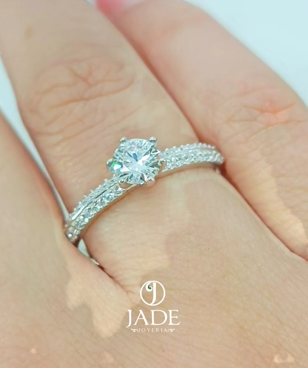 Jade18k engagement ring in silver with a central diamond and pave-set stones on the band.