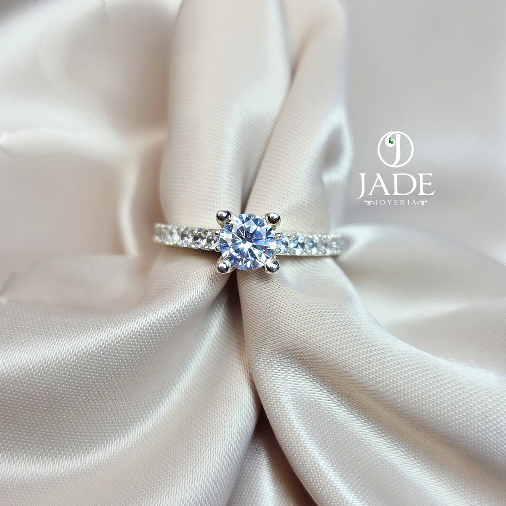 Jade18k Rafaella engagement ring in silver with a central round-cut cubic zirconia and pavé band.