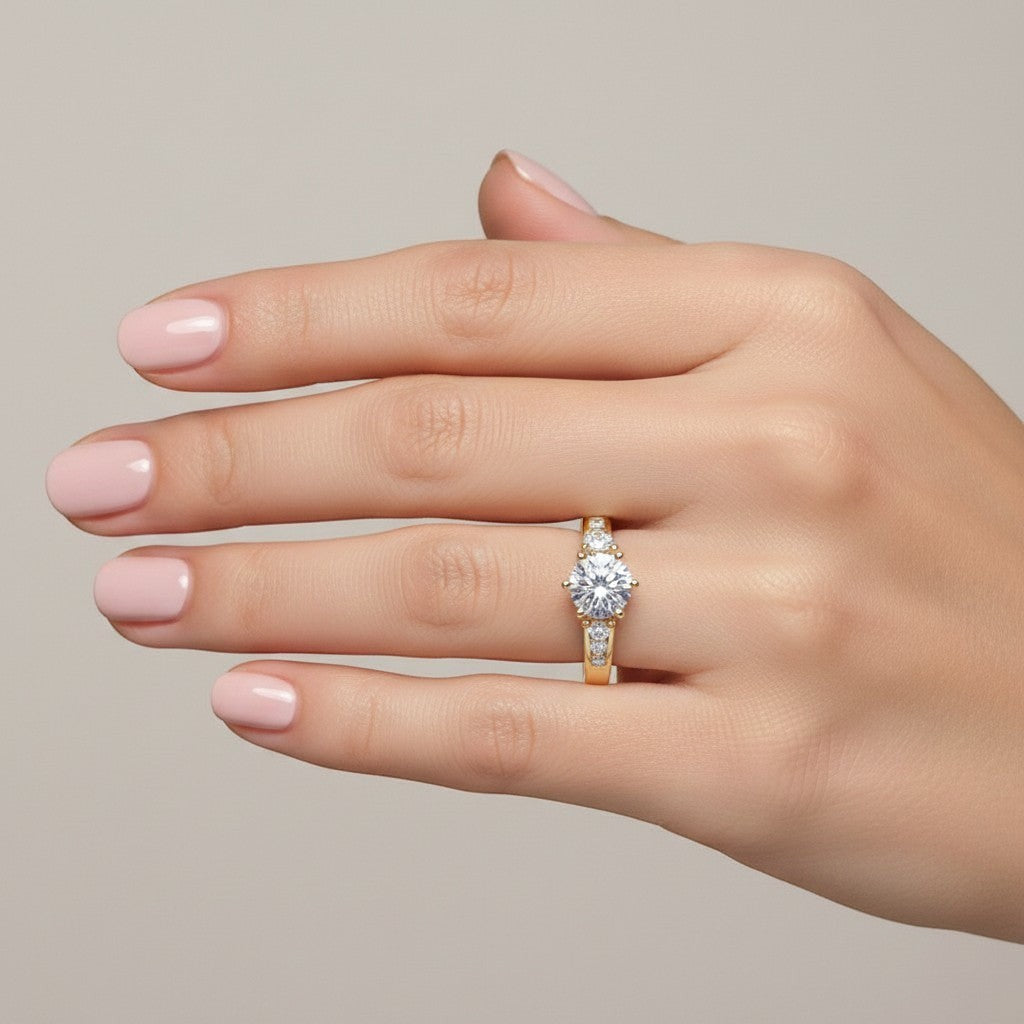 Jade18k yellow gold three-stone engagement ring with round-cut center stone and channel-set accent stones.