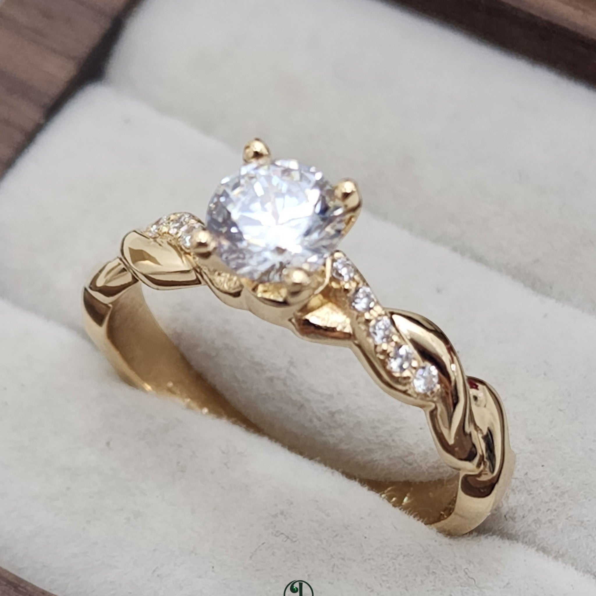 Jade18k yellow gold twisted band solitaire ring with pave-set stones and a central diamond.