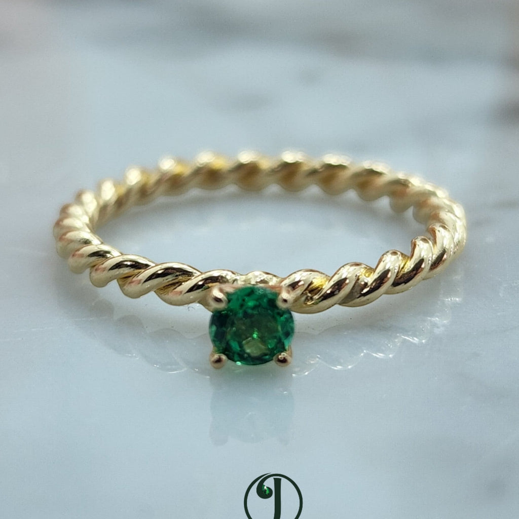 Jade18k twisted band solitaire ring with a round green emerald centerpiece, crafted from 14k yellow gold.