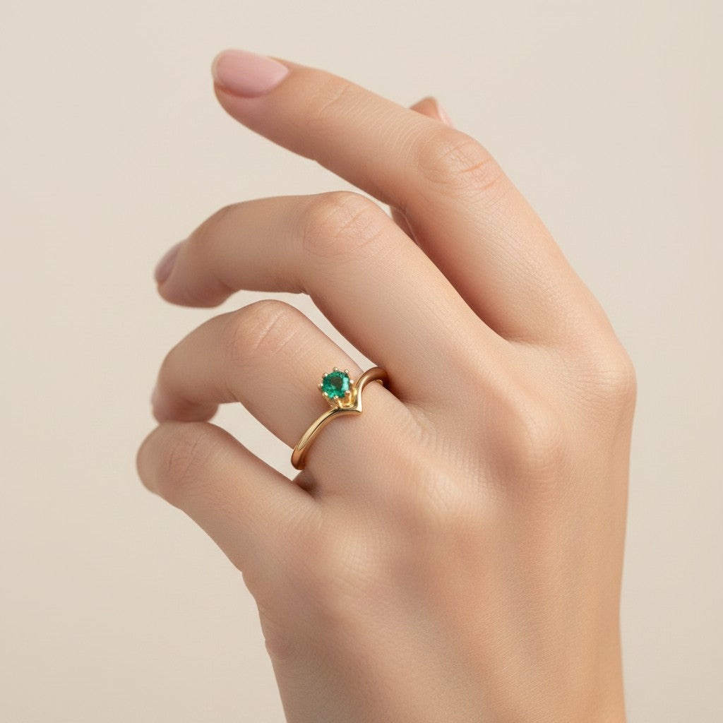 Jade18k yellow gold ring with a small emerald gemstone set in a crown-like prong setting.