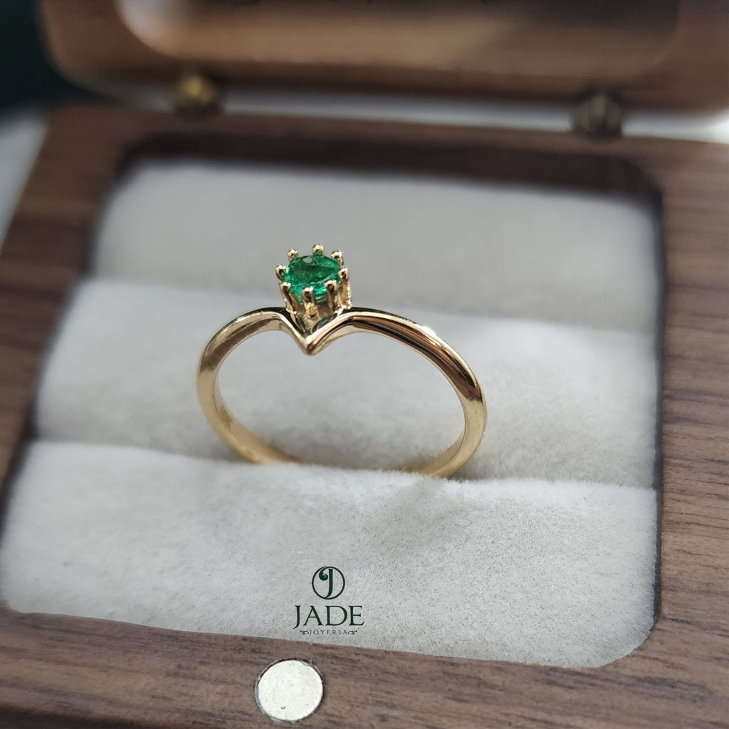 Jade18k yellow gold ring with a small green emerald set in a V-shaped band.