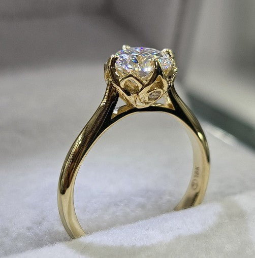 Jade18k 18k yellow gold engagement ring with a large round-cut center stone and floral-inspired setting with small accent stones.