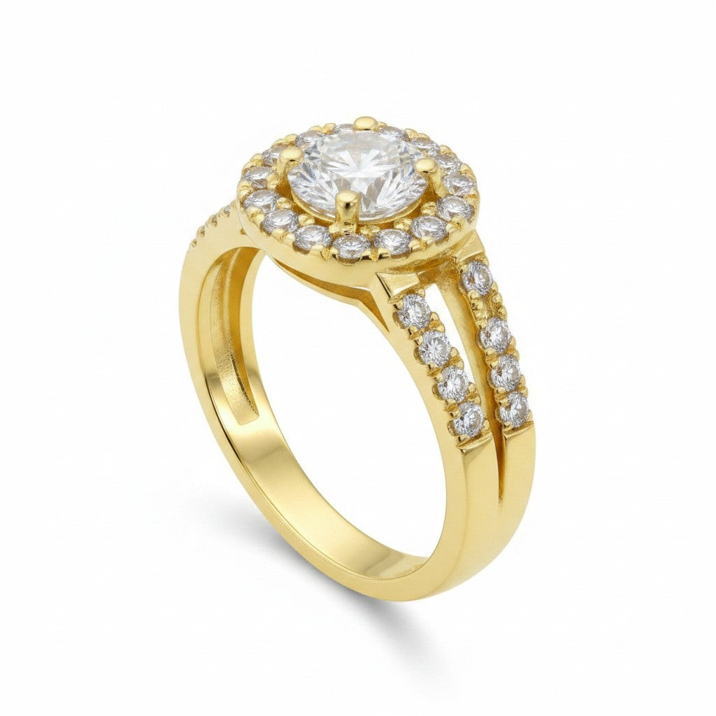 Jade18k Raquel engagement ring in 18k yellow gold with a central round-cut zircon surrounded by a halo of smaller stones. Split band adorned with pave-set stones.