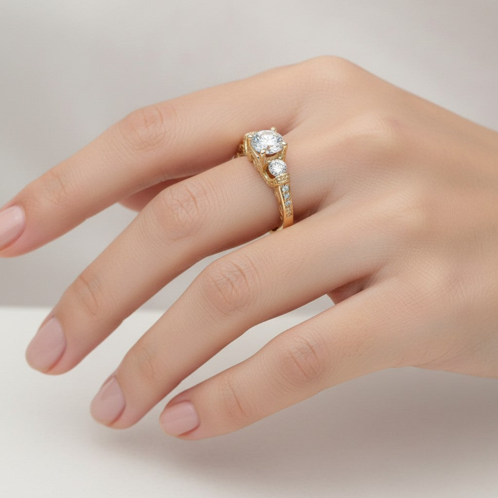 Jade18k Legado Divino 18k yellow gold engagement ring with a central zircon and two side stones, featuring intricate scrollwork and pave details.