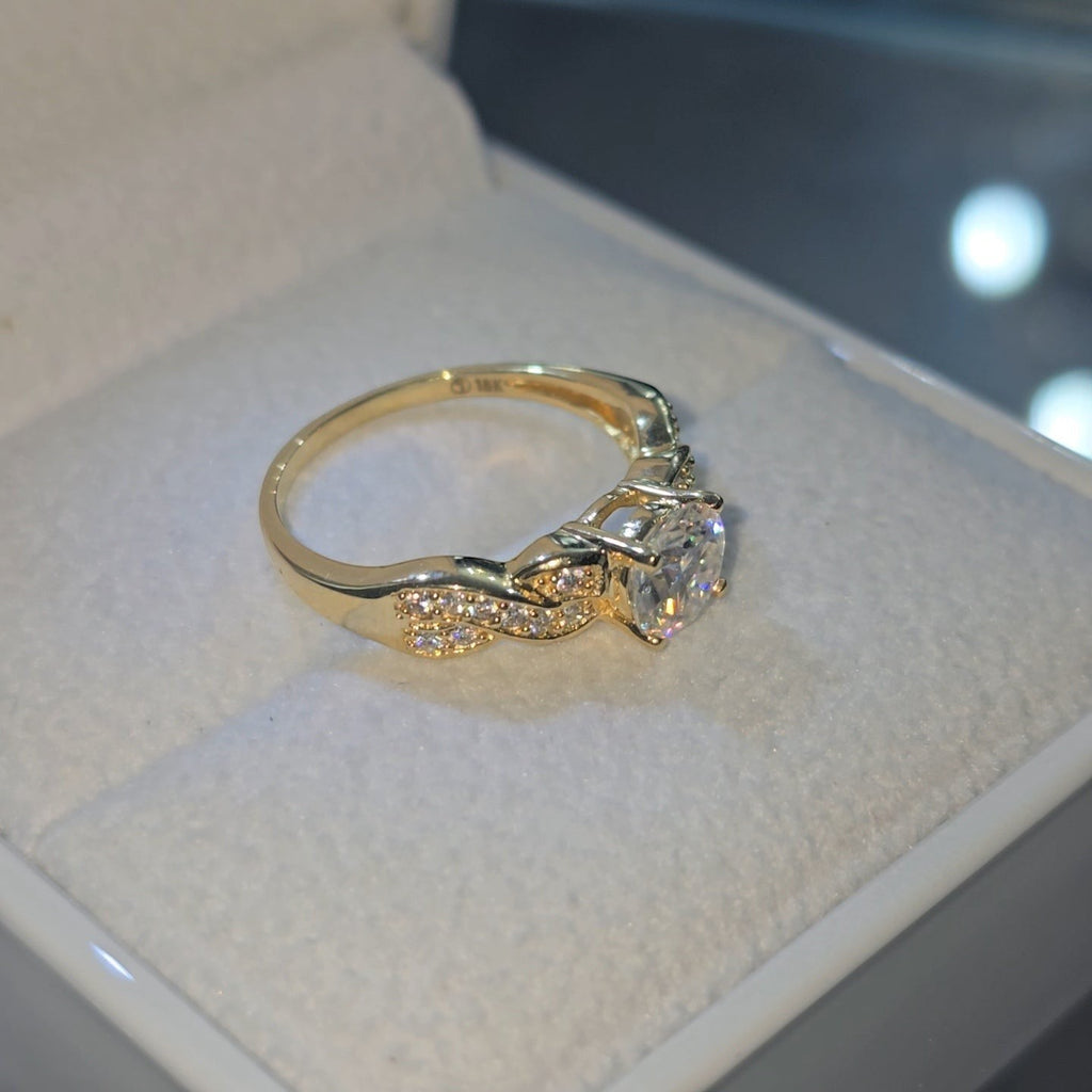 Jade18k 18k yellow gold engagement ring with a large center stone and small accent stones on a twisted band.