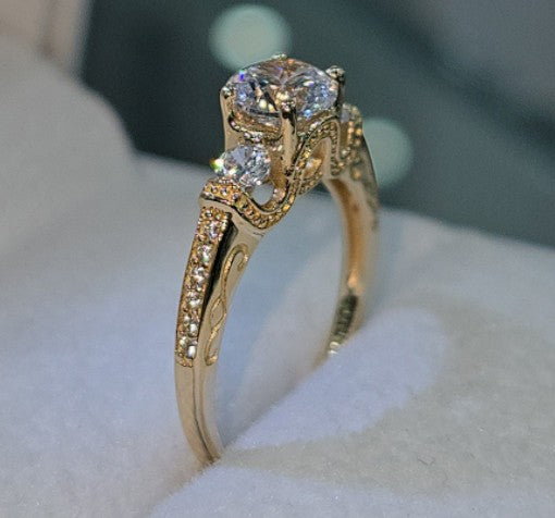Jade18k Legado Divino 18k yellow gold engagement ring with a central zircon and smaller stones on the band.