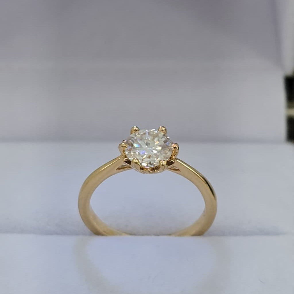 Jade18k engagement ring with a round moissanite center stone set in yellow gold.