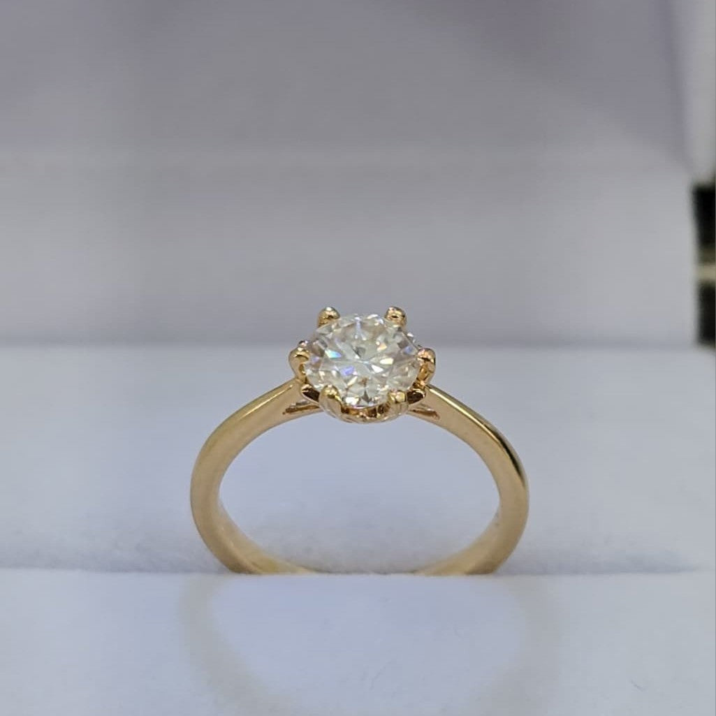 Jade18k engagement ring with a round moissanite center stone set in yellow gold.