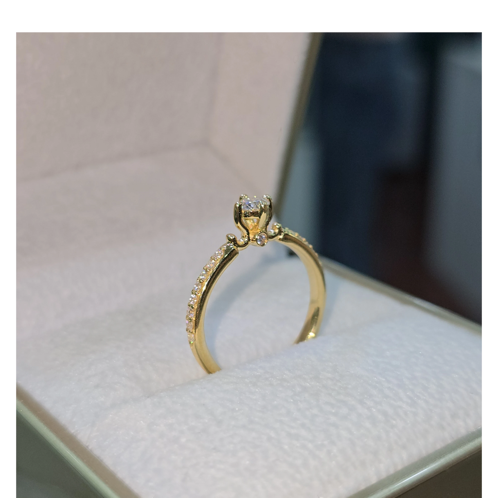 Jade18k 18k yellow gold engagement ring with a central moissanite stone and pavé set stones along the band.
