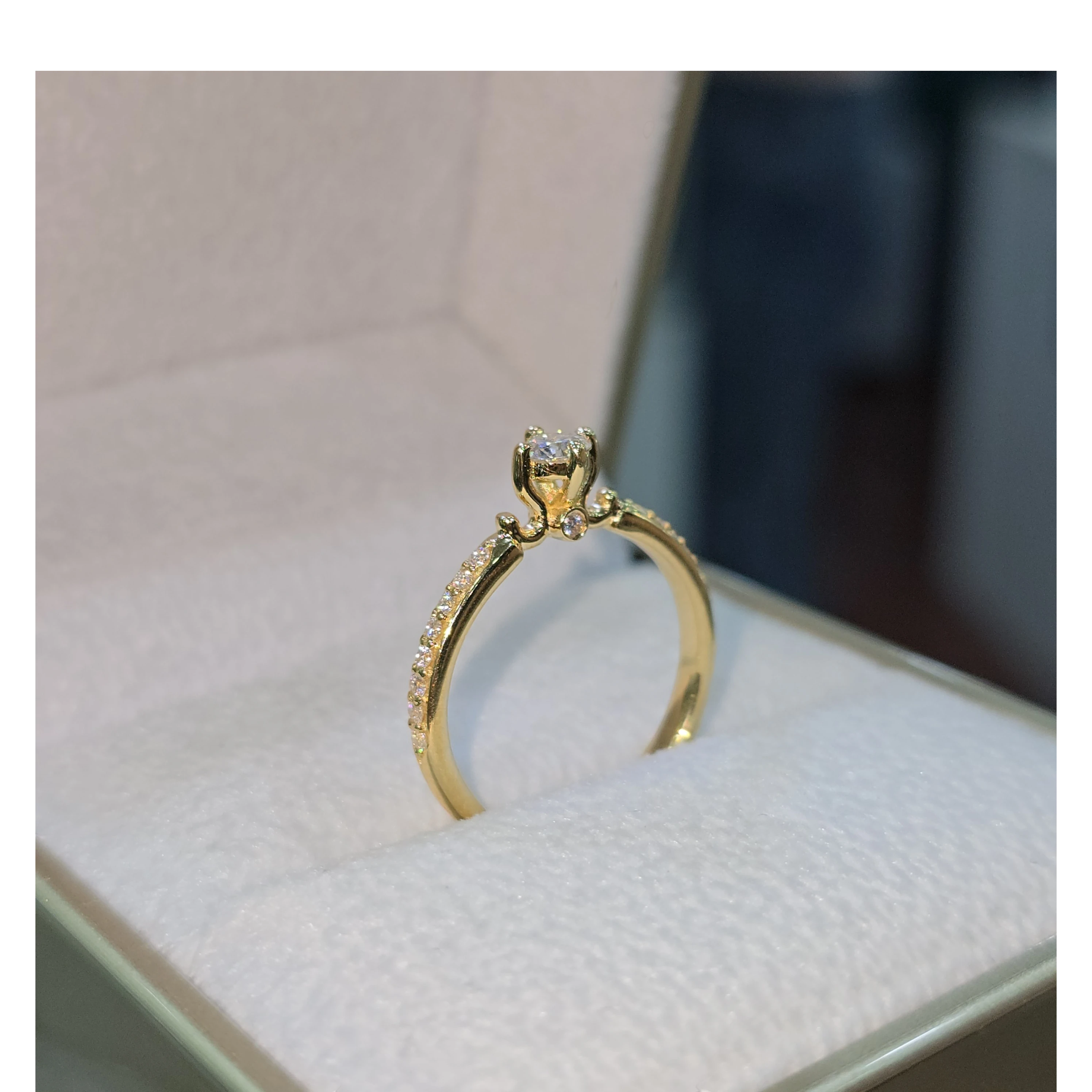 Jade18k 18k yellow gold engagement ring with a central moissanite stone and pavé set stones along the band.
