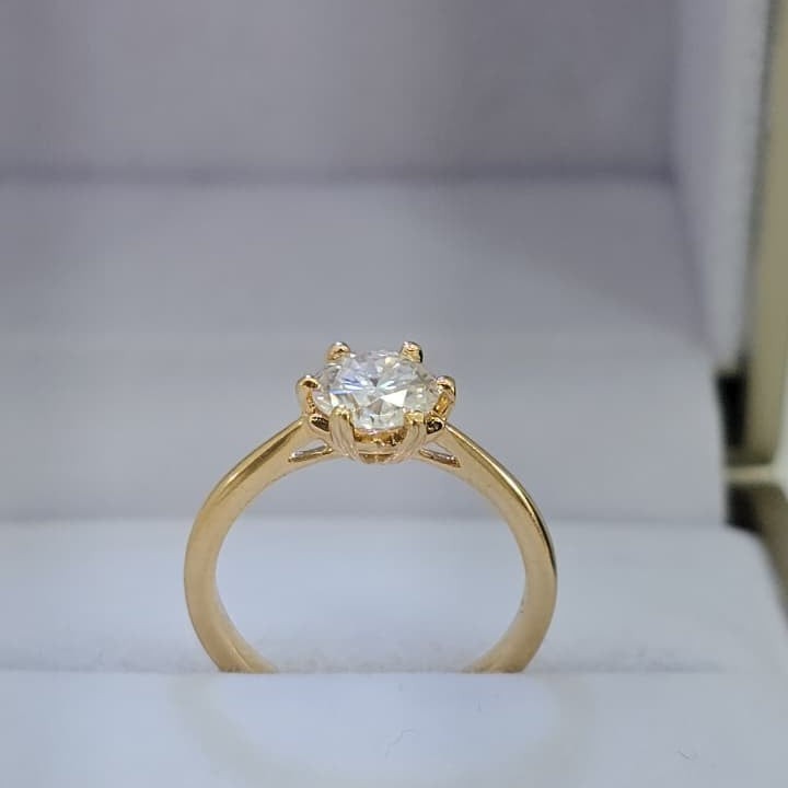 Jade18k yellow gold engagement ring with a round moissanite center stone, six-prong setting.