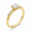 Jade18k 18k yellow gold engagement ring with princess-cut moissanite center stone and channel-set accent stones.