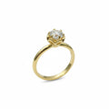Jade18k engagement ring with a round moissanite stone set in 18k yellow gold with a floral-inspired setting.