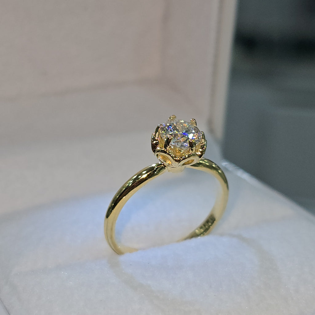 Jade18k engagement ring with a solitaire moissanite stone set in 18k yellow gold with a floral-inspired setting.