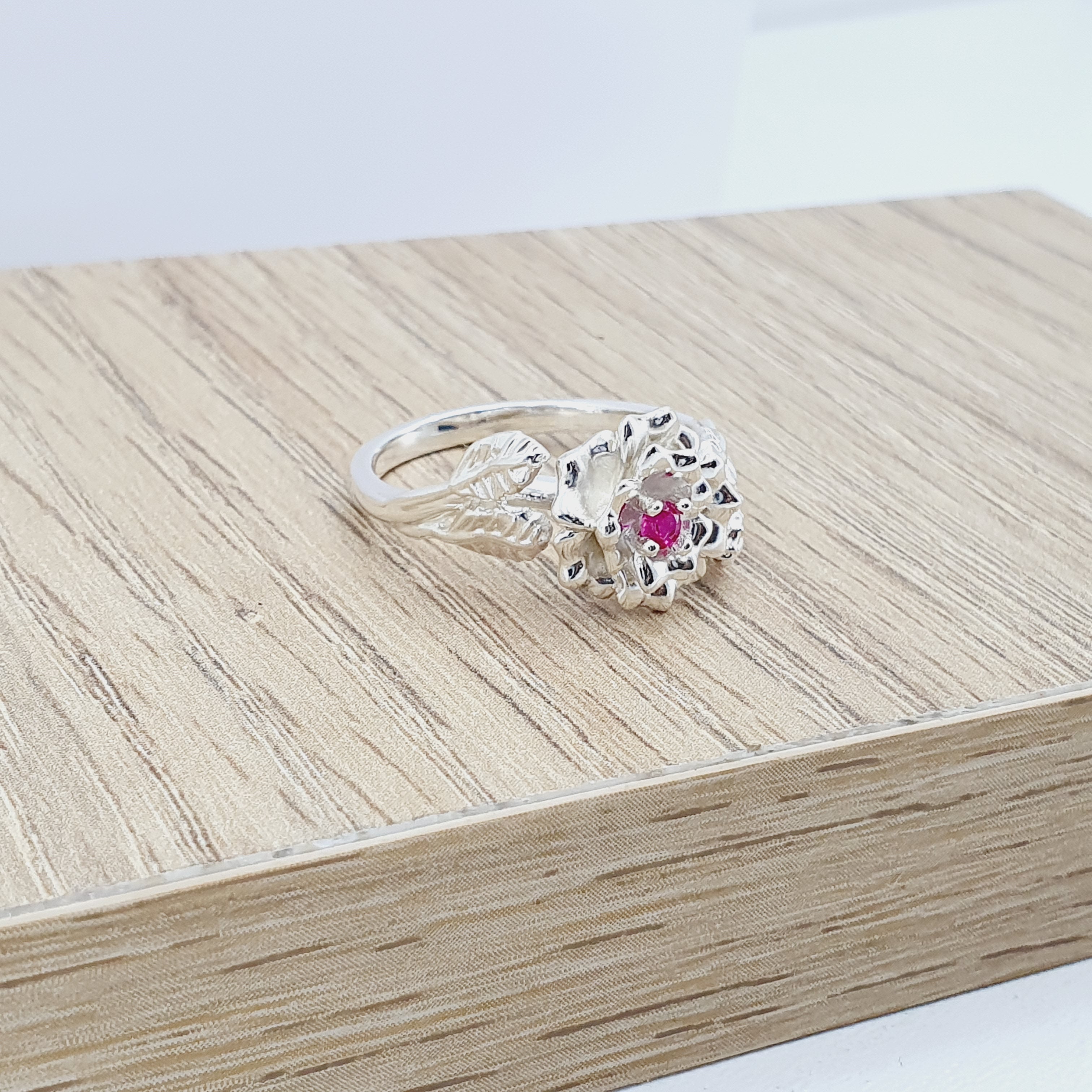 Anillo tipo flor labrada en plata con circon